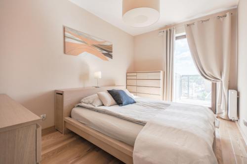 a bedroom with a bed and a large window at CITYSTAY Szafarnia Gdansk Apartment in Gdańsk