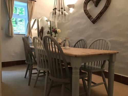 - une salle à manger avec une table et des chaises en bois dans l'établissement Riverwash Cottage, à Penmaen-mawr