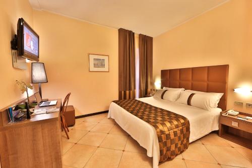 una camera d'albergo con un letto e una TV a schermo piatto di Best Western Hotel Libertà a Modena