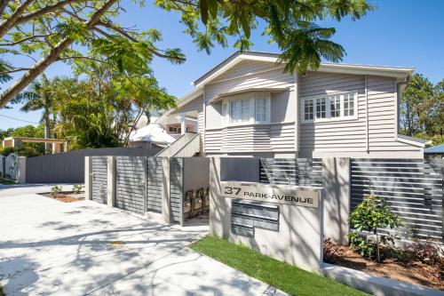 a white house with a sign in front of it at Park Avenue 1BR Hideaway King Bd Private Courtyard in Brisbane