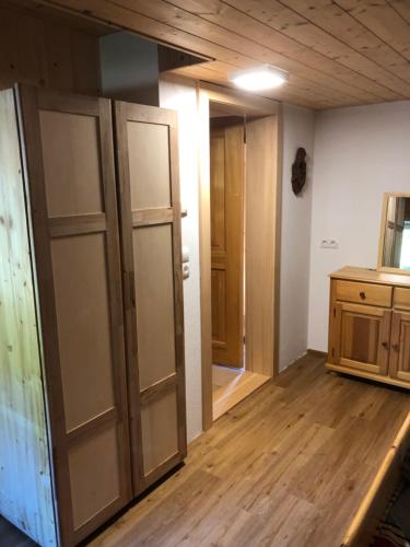 an empty room with wooden floors and a room with doors at Ferienhaus am Waldrand von Egg Bregenzer Wald in Egg