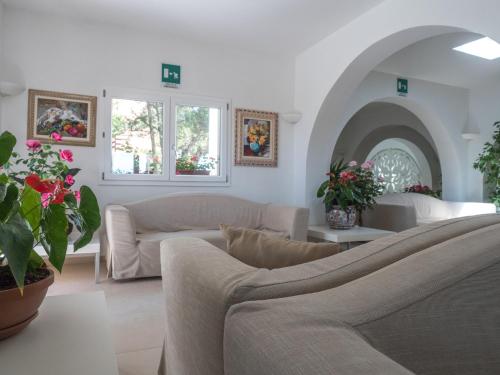 a living room filled with furniture and flowers at Hotel Cala Reale in Stintino