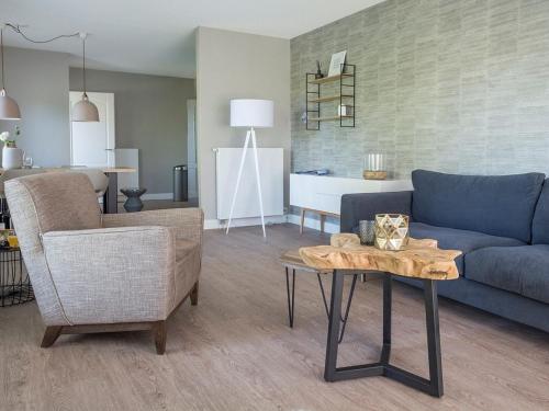 Una sala de estar con un sofá azul y una mesa. en Apartment in De Cocksdorp near Beach, en De Cocksdorp