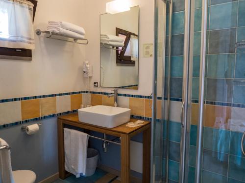 
a bathroom with a toilet, sink, and shower stall at Hotel Cala Reale in Stintino
