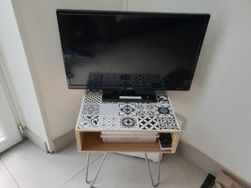 a computer monitor on a table with a television at Adopt'île in Le Château-dʼOléron