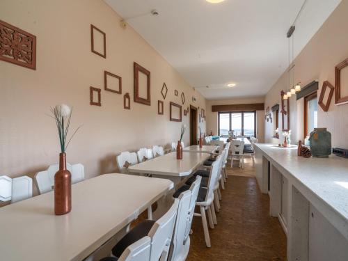 uma sala de jantar com mesas brancas e cadeiras brancas em Spacious Holiday Home in Gouvy with Garden em Gouvy