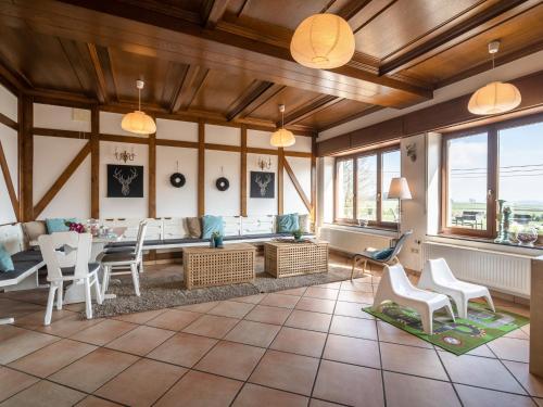 - un salon avec une table, des chaises et des fenêtres dans l'établissement Spacious Holiday Home in Gouvy with Garden, à Gouvy