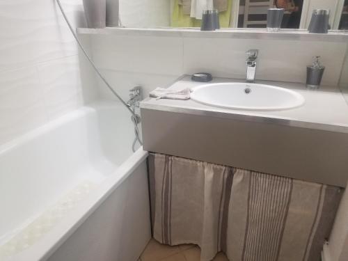 une salle de bain blanche avec un lavabo et un miroir dans l'établissement Port Vincent, à La Grande Motte
