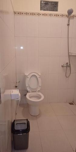 a bathroom with a toilet and a trash can at Pondok Aldi in Amed