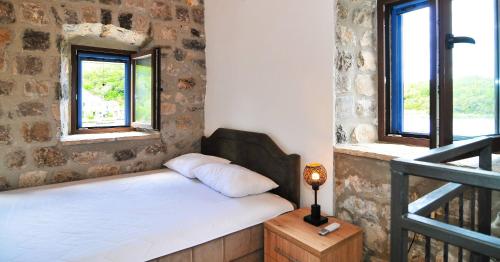 una camera con un letto e due finestre di Trip to a Tivat