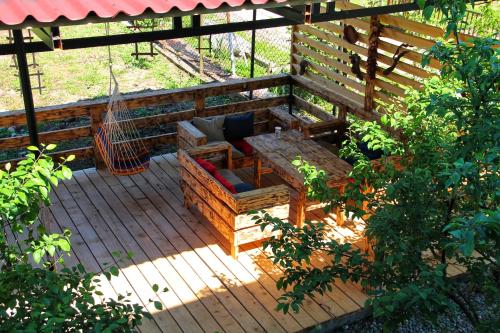 a wooden bench sitting on a wooden deck at Эко-комплекс Ахаца in Sukhum