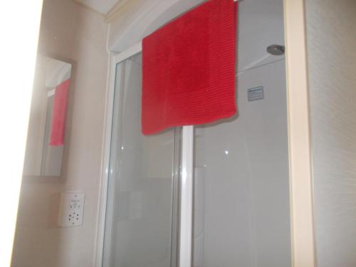 a shower with a red towel on top of it at ty gwyn in Abergele