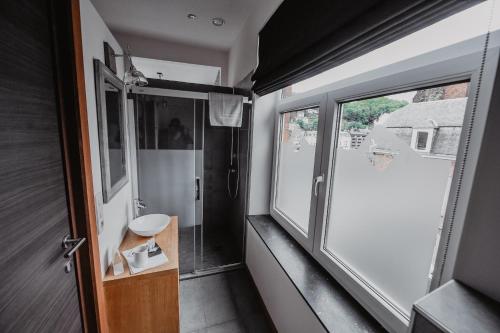 a small bathroom with a sink and a window at Côté Sax bed and breakfast in Dinant
