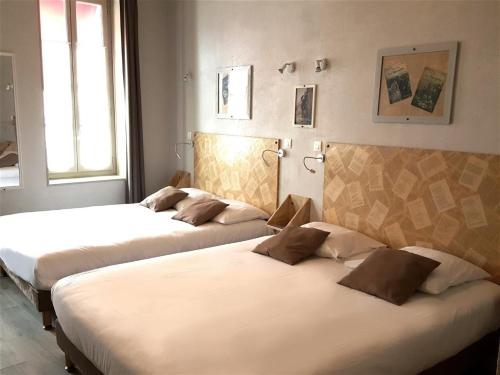 Ένα ή περισσότερα κρεβάτια σε δωμάτιο στο Hôtel Mille et une Feuilles