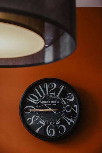 a clock on a wall next to a lamp at Côté Sax bed and breakfast in Dinant