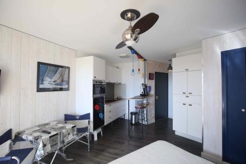 cocina con armarios blancos y ventilador de techo en Studio vue mer et Cap en Canet-en-Roussillon