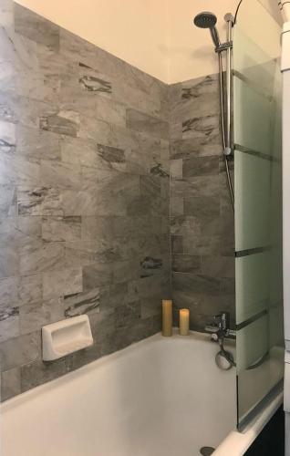 La salle de bains est pourvue d'une baignoire avec un mur en pierre. dans l'établissement Lovely Flat Champs de Mars Eiffel, à Paris