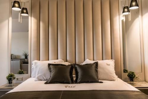 a bedroom with a large bed with white pillows at Ask Cozy Rooms in Thessaloniki