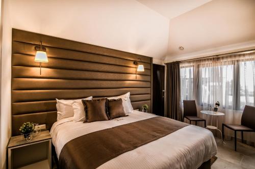 a hotel room with a large bed with a wooden headboard at Ask Cozy Rooms in Thessaloniki