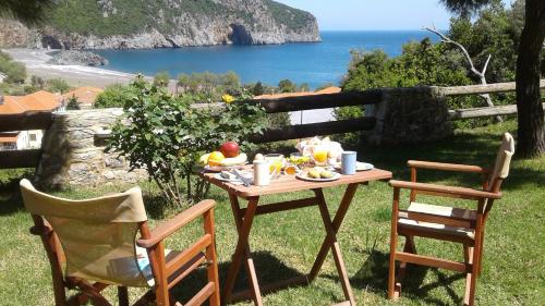 a table and two chairs with a meal on the grass at Lithoktisto in Limnionas