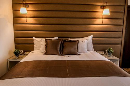 a bedroom with a large bed with a wooden headboard at Ask Cozy Rooms in Thessaloniki