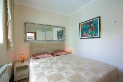 a bedroom with a bed with a mirror on the wall at Apartments Holiday Lux in Sutomore