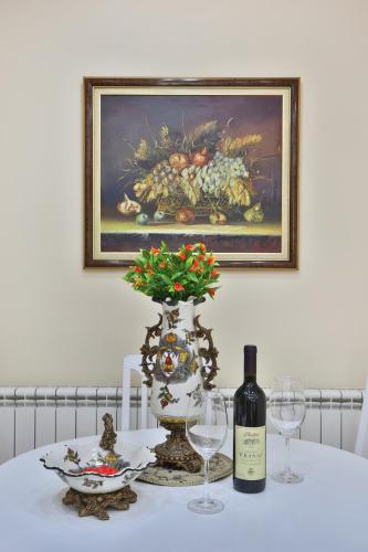 a table with a bottle of wine and two glasses at Apartments Holiday Lux in Sutomore