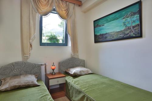 1 Schlafzimmer mit 2 Betten und einem Fenster in der Unterkunft Apartments Holiday Lux in Sutomore