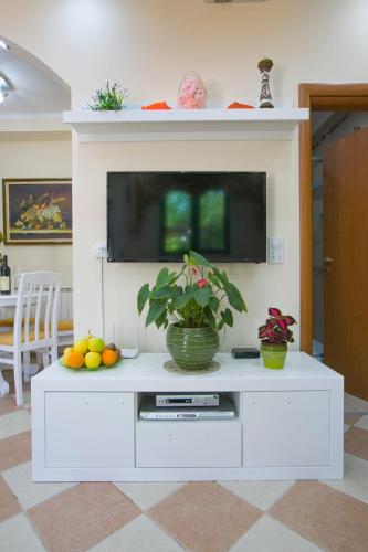 a white entertainment center in a living room with a tv at Apartments Holiday Lux in Sutomore