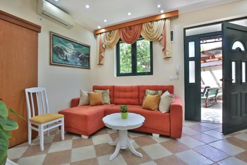 a living room with a red couch and a table at Apartments Holiday Lux in Sutomore