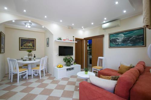 a living room with a red couch and a table at Apartments Holiday Lux in Sutomore