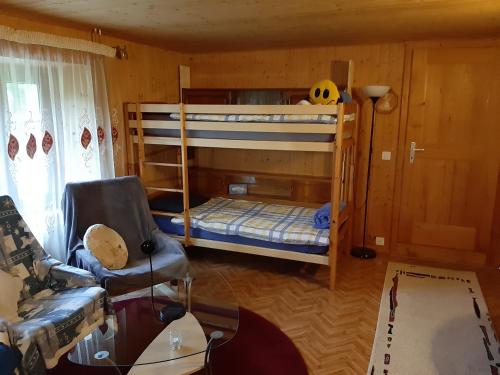 - un salon avec 2 lits superposés et un canapé dans l'établissement La Dernier (La cote-aux-fées) Suisse, à La Côte-aux-Fées
