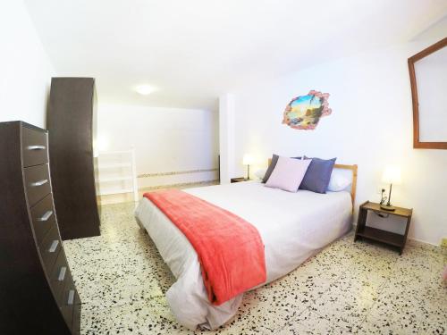 een slaapkamer met een groot bed met een rode deken bij Carta Apartment in San Andrés in San Andrés