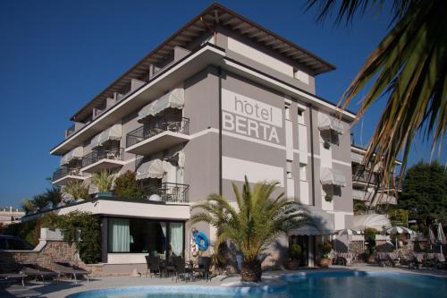 a hotel with a swimming pool in front of a building at Hotel Berta in Desenzano del Garda