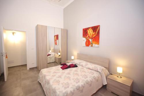 a bedroom with a bed and a painting on the wall at Casa Vignale in Avola