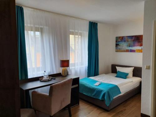 Hotel Milin في رايشنباخ إم فوغتلاند: غرفة نوم بسرير ومكتب وكرسي