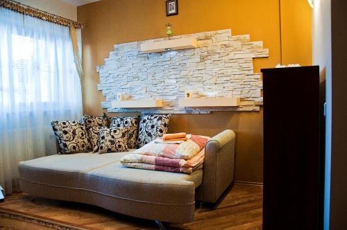 a living room with a couch and a brick wall at Dworek Jolanta in Biała Podlaska