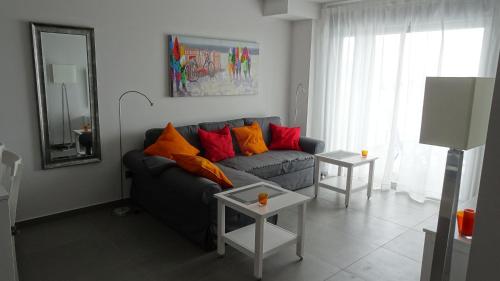 a living room with a couch with colorful pillows at Sotavento Las Terrazas II, La Tejita in La Tejita