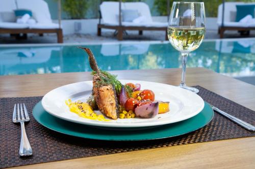 a plate of food on a table with a glass of wine at AWA Boutique + Design Hotel in Punta del Este