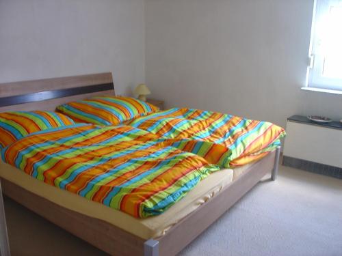 a bed with a colorful blanket on top of it at Ferienwohnung Lindlar in Lindlar