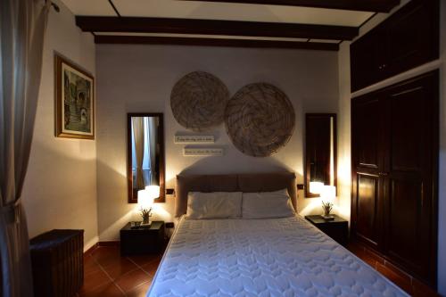 una camera con un grande letto con due lampade di Casa Lorenza a Portovenere