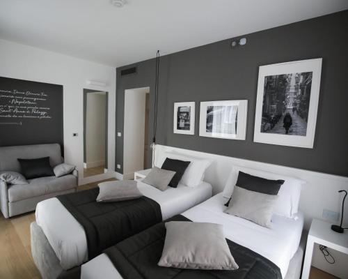 una camera d'albergo con due letti e un divano di B&B LIONORA a Napoli