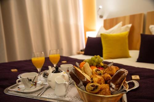 - une table avec un plateau de nourriture et 2 verres de jus d'orange dans l'établissement Hotel Les Vallées Labellemontagne, à La Bresse