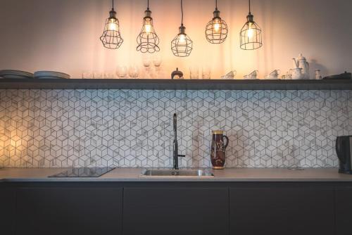 a kitchen counter with a sink and some lights at Lackenbauer in Muggenau