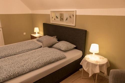 a bedroom with a large bed and a table with a lamp at Lackenbauer in Muggenau