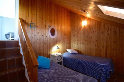 a bedroom with two beds in a wooden wall at VILLA DEL GOLF in Pals