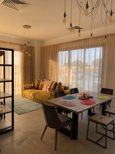 una sala de estar con una mesa y un sofá en Flamingo City Lux, en Famagusta