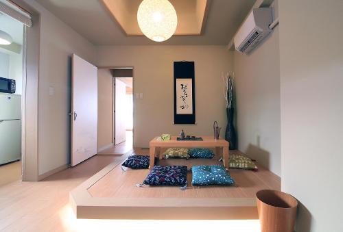 東京的住宿－TOMARU MORISITA HOUSE，客厅配有桌子和枕头,位于地板上