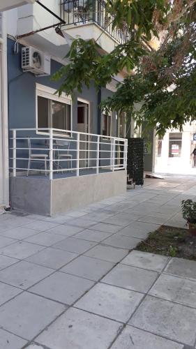 a blue building with a balcony and a porch at Elena Rooms-Apartments -B in Asprovalta