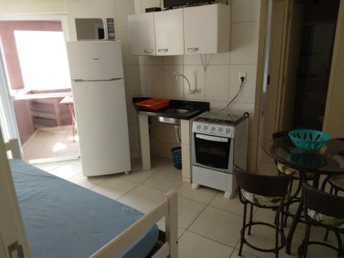 una pequeña cocina con refrigerador blanca y mesa en Residencial Melfi 3 Ap.5 Lateral, en Bombinhas